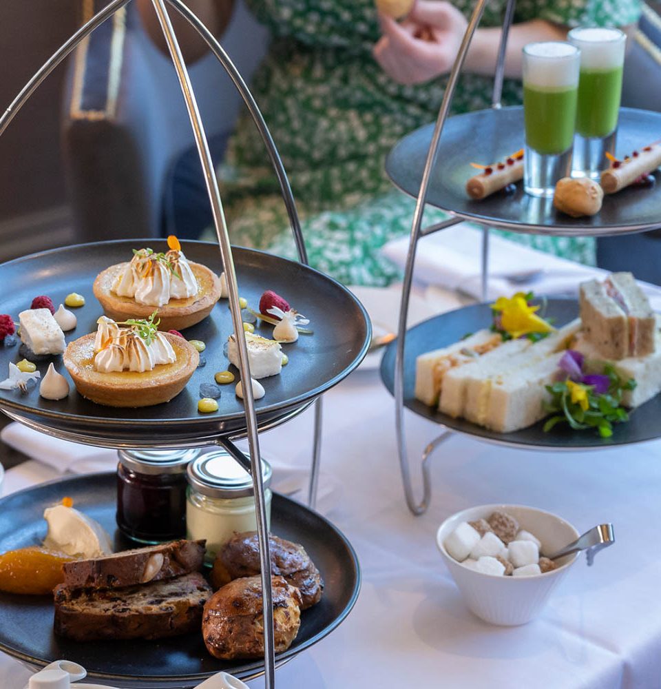 Selection of food sitting on black plates in silver stands