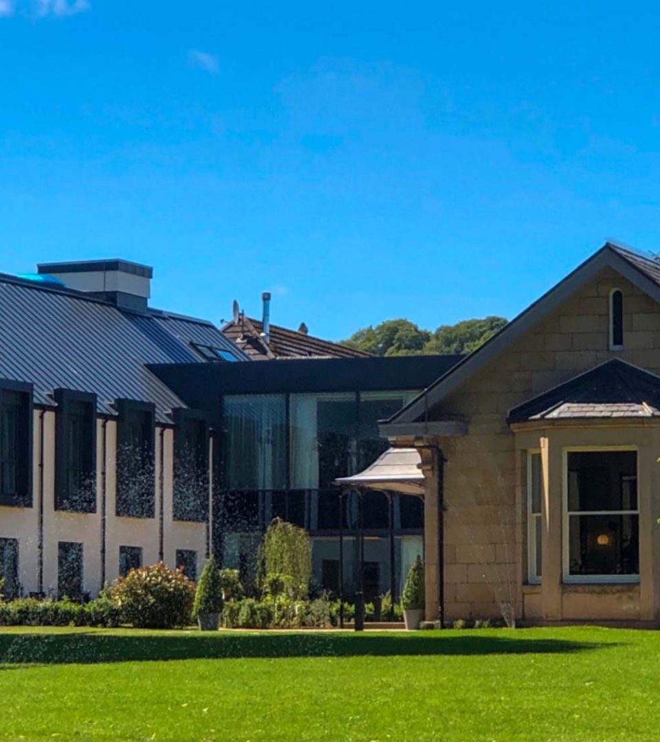 Exterior of the hotel with blue skies and green grass