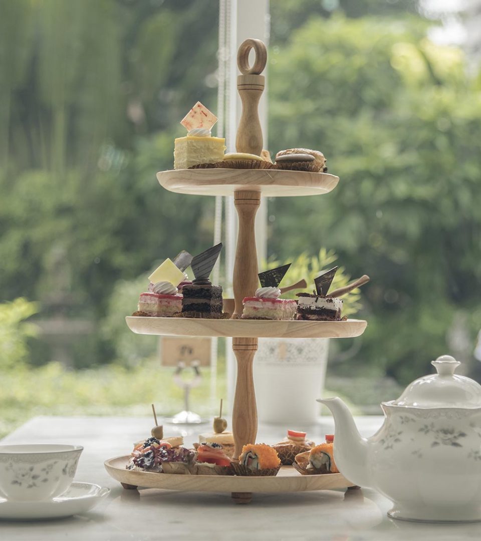 A heavenly afternoon tea with a cake tier and a pot of tea.