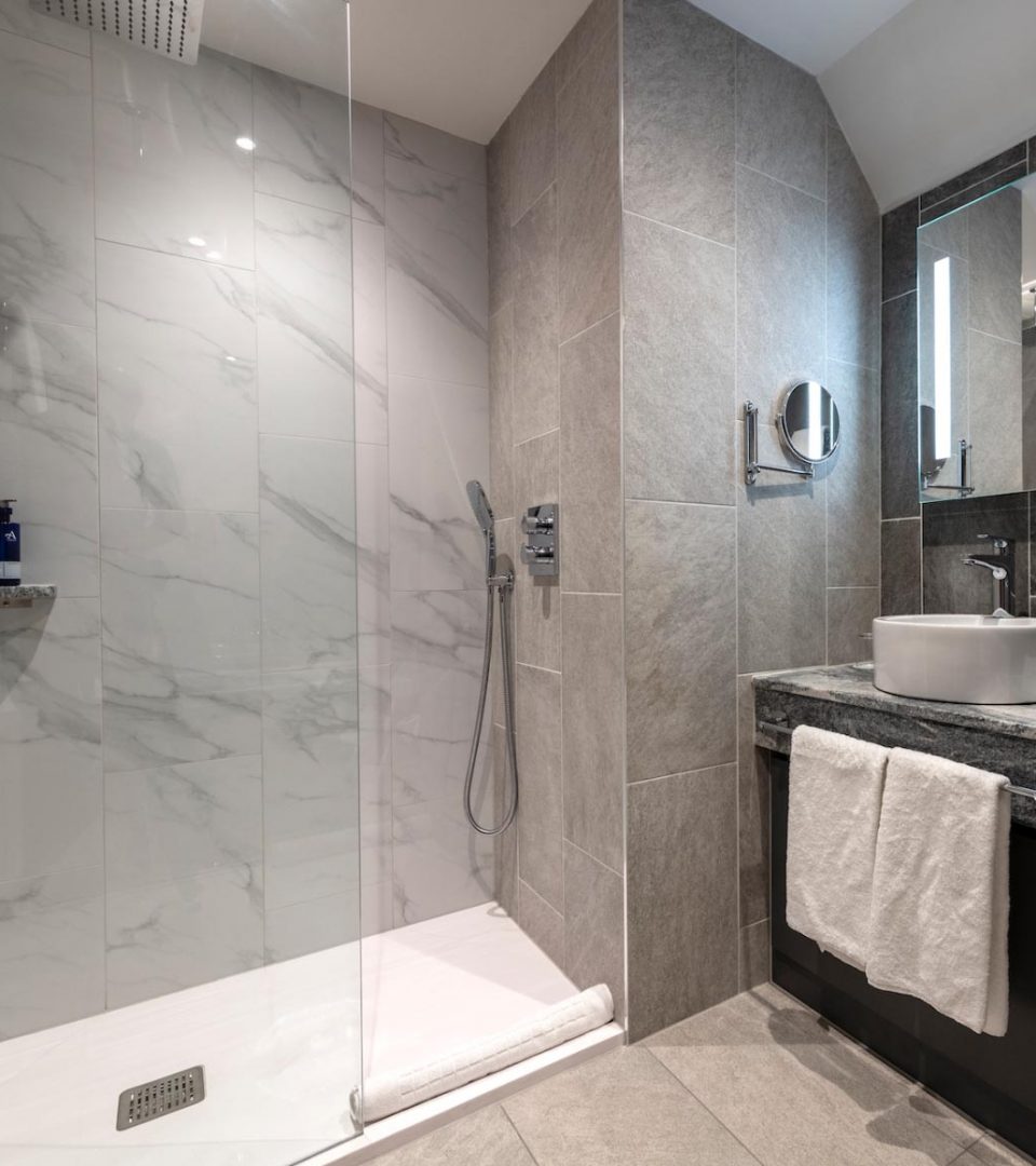 marbled bathroom with shower and sink