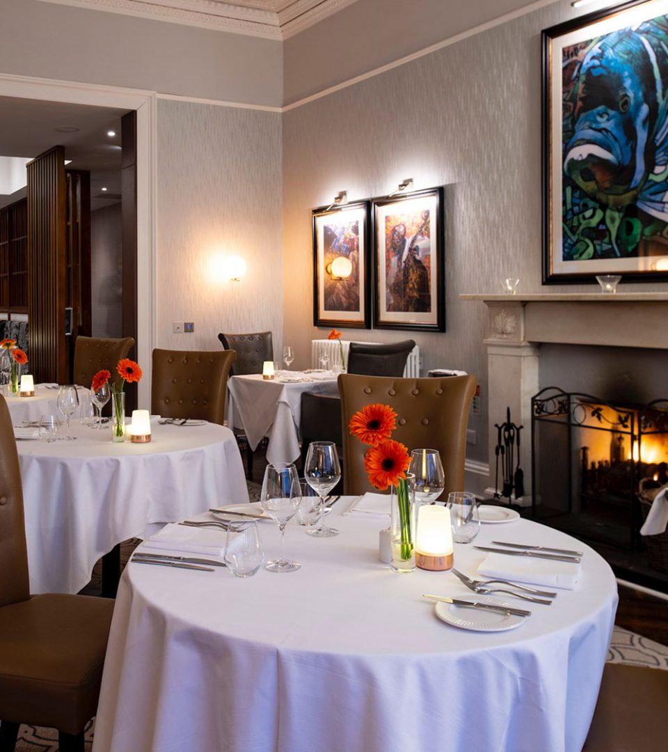 Restaurant set for evening service with fireplace lit