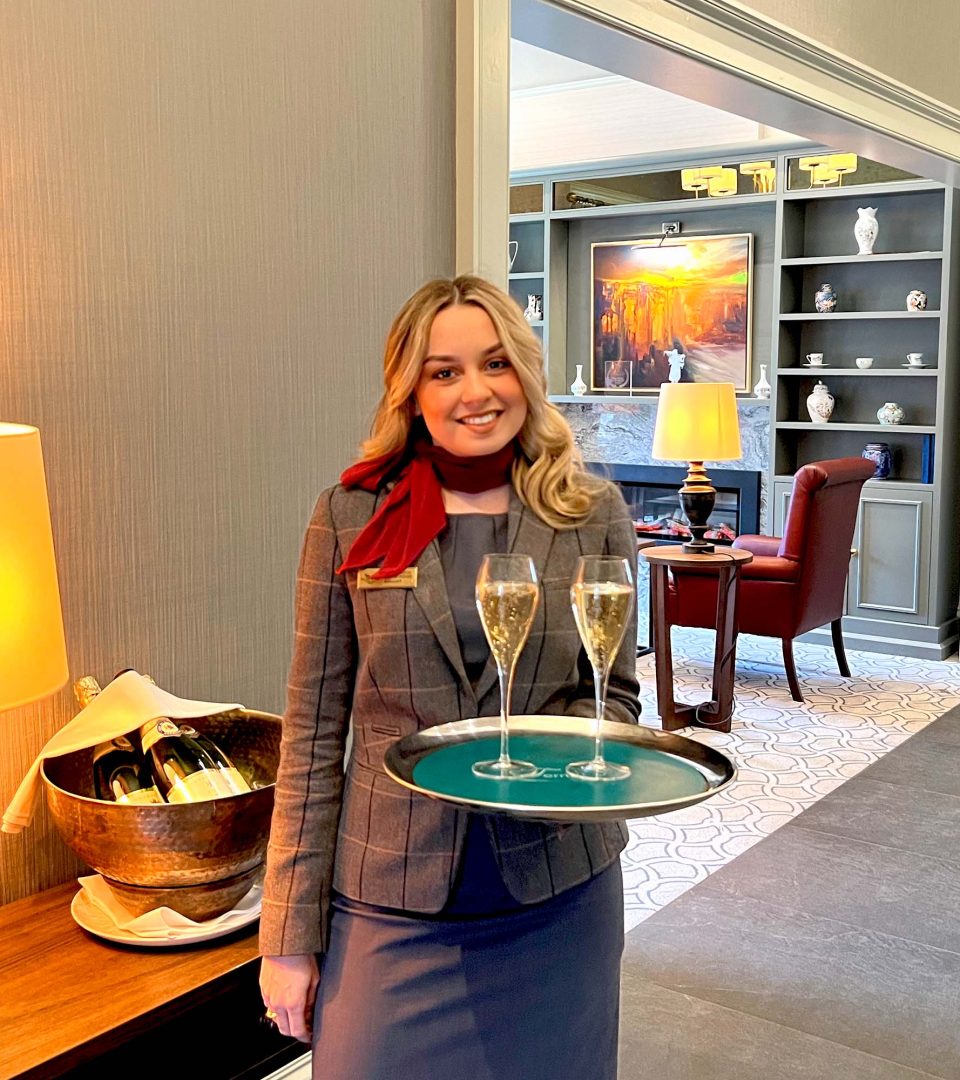 Staff member with Champagne glasses on a tray at Ness Walk Hotel