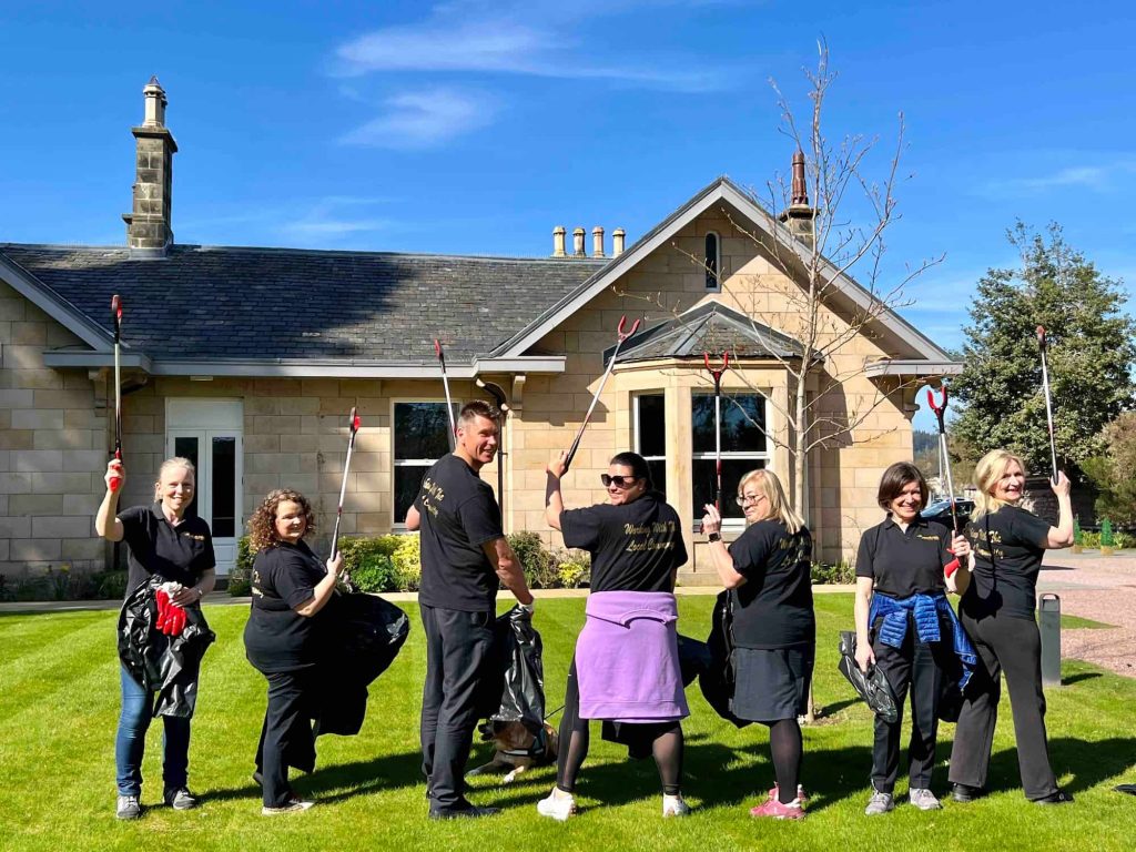 Ness Walk team gather outside Ness Walk on the hotel lawn ahead of a litter pick.