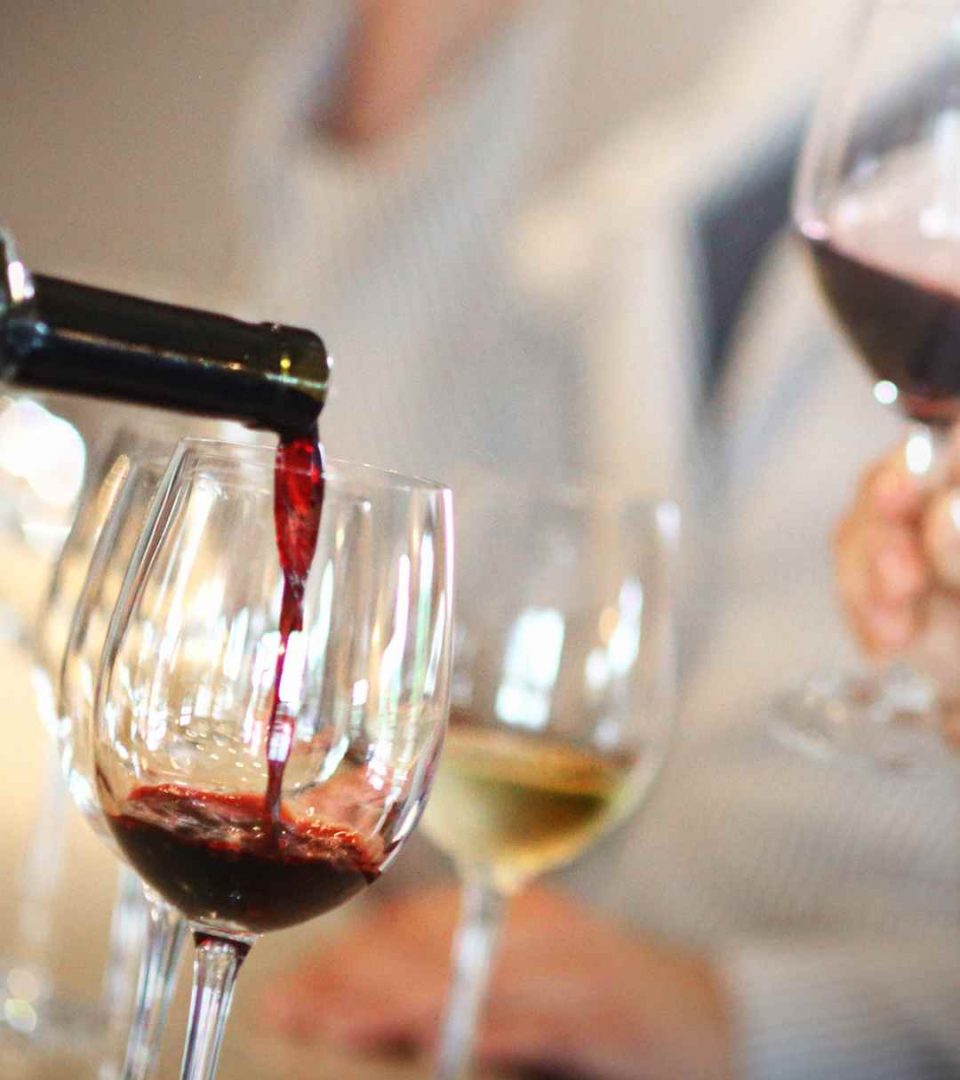 Wine glasses being poured in a tasting session