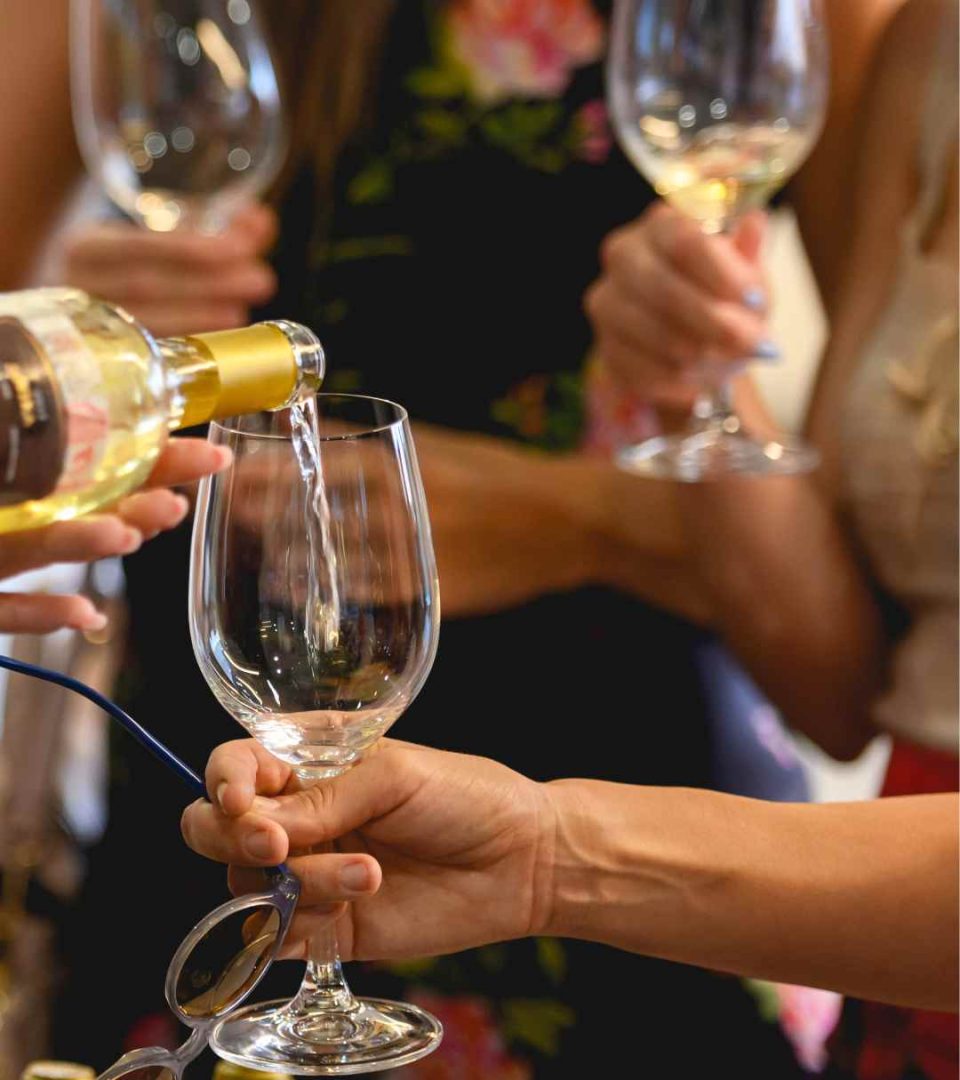 Guests enjoying a wine tasting session with glasses half full and guests mingling