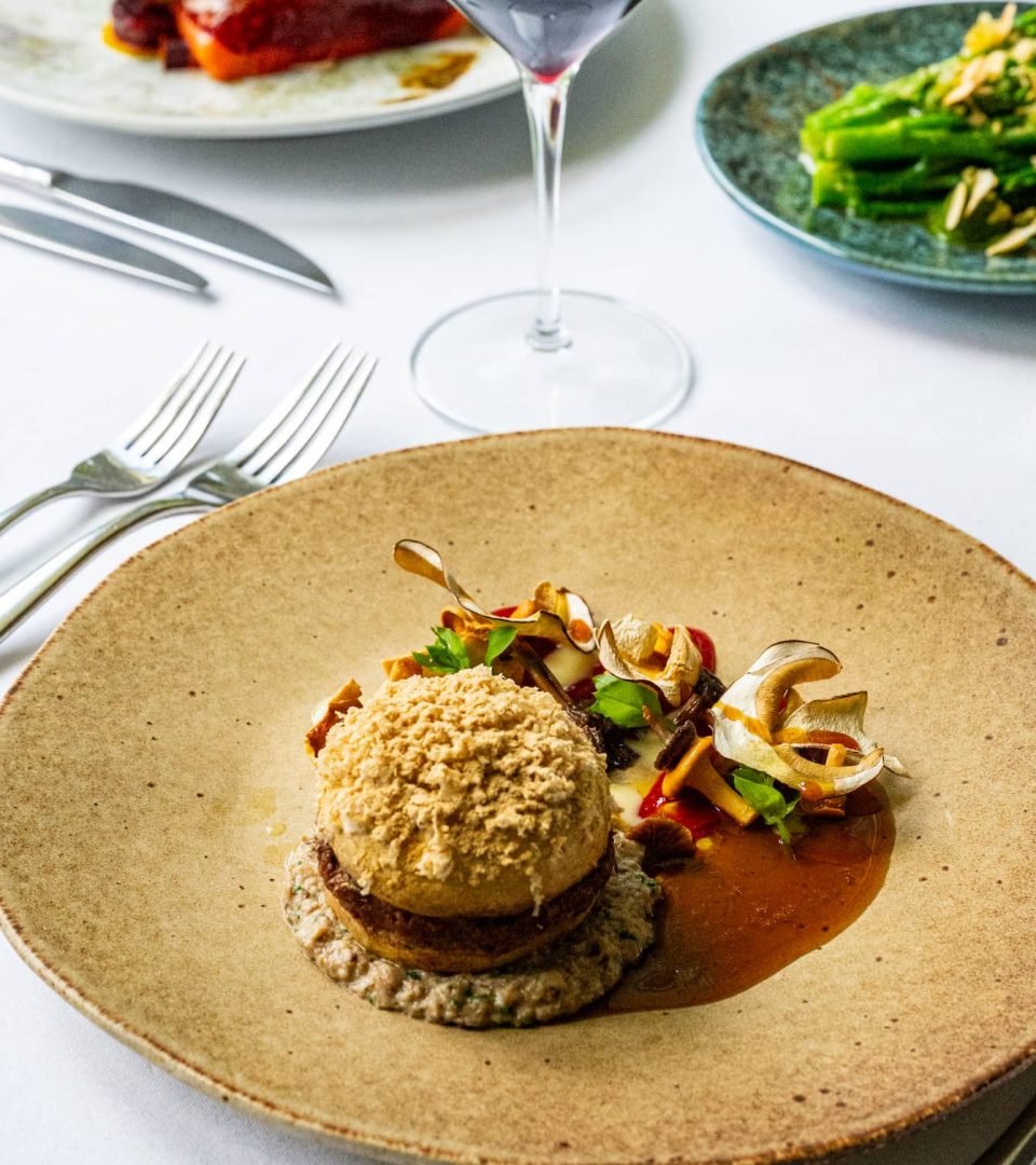 Foraged mushrooms in a colourful main course at Torrish with Red Wine in background