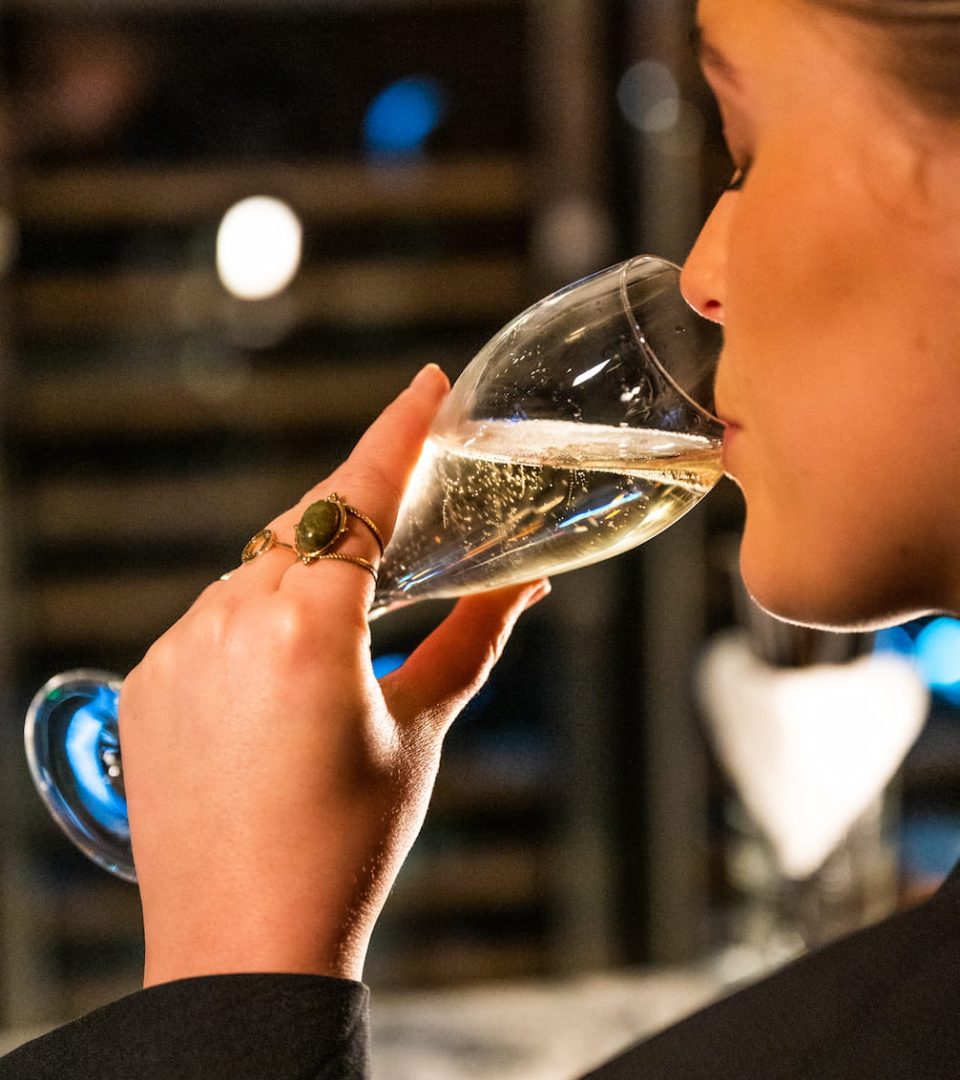 Lady sipping champagne during Alpine wine tasting at the Ness Walk bar