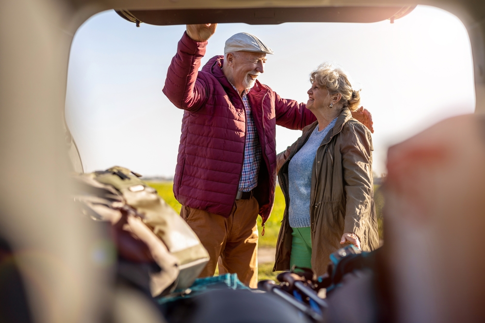 Senior couple packing a car.