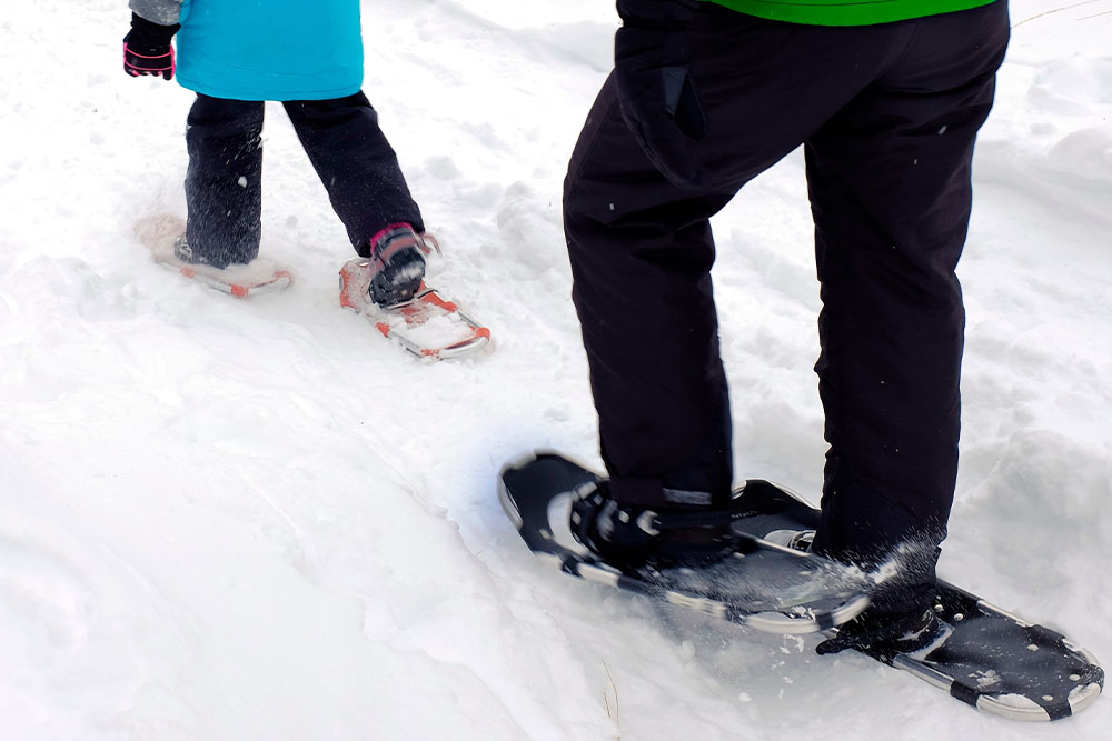 A woman and child in snowshoes.