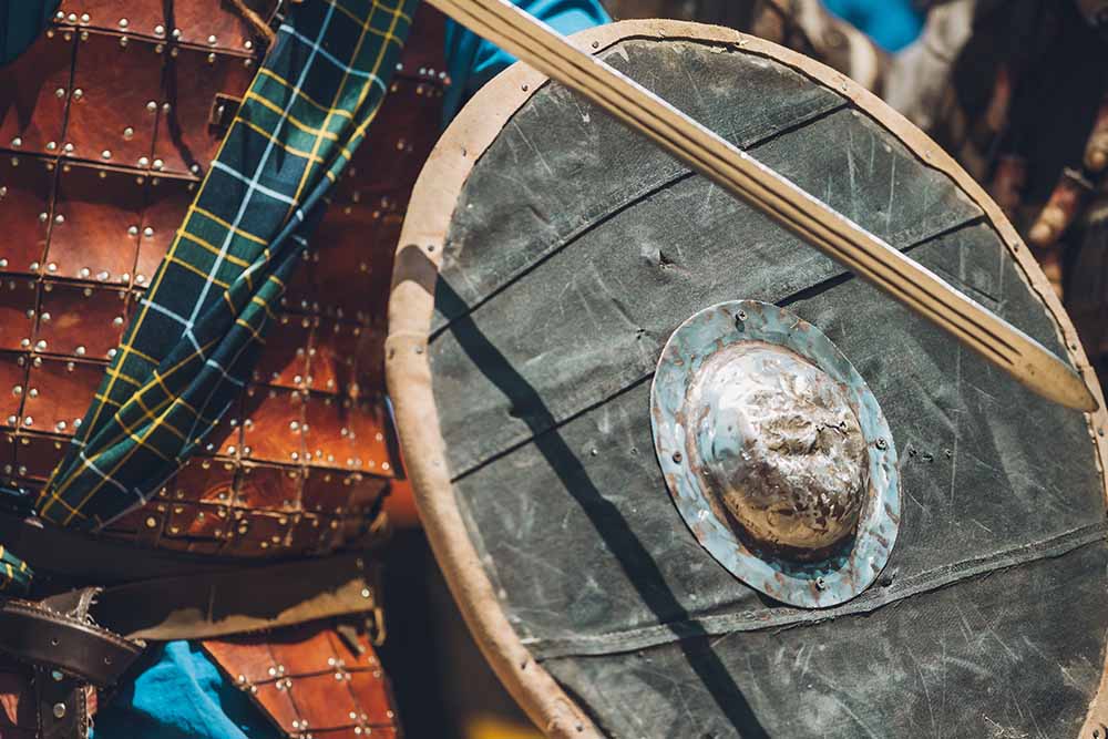 A shield and tartan in an old Highland battle costume.