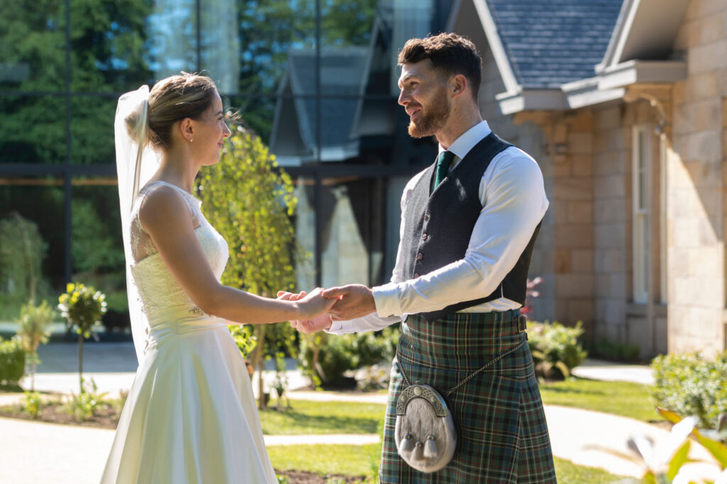 Bride and Groom looking at one another and holding hands 